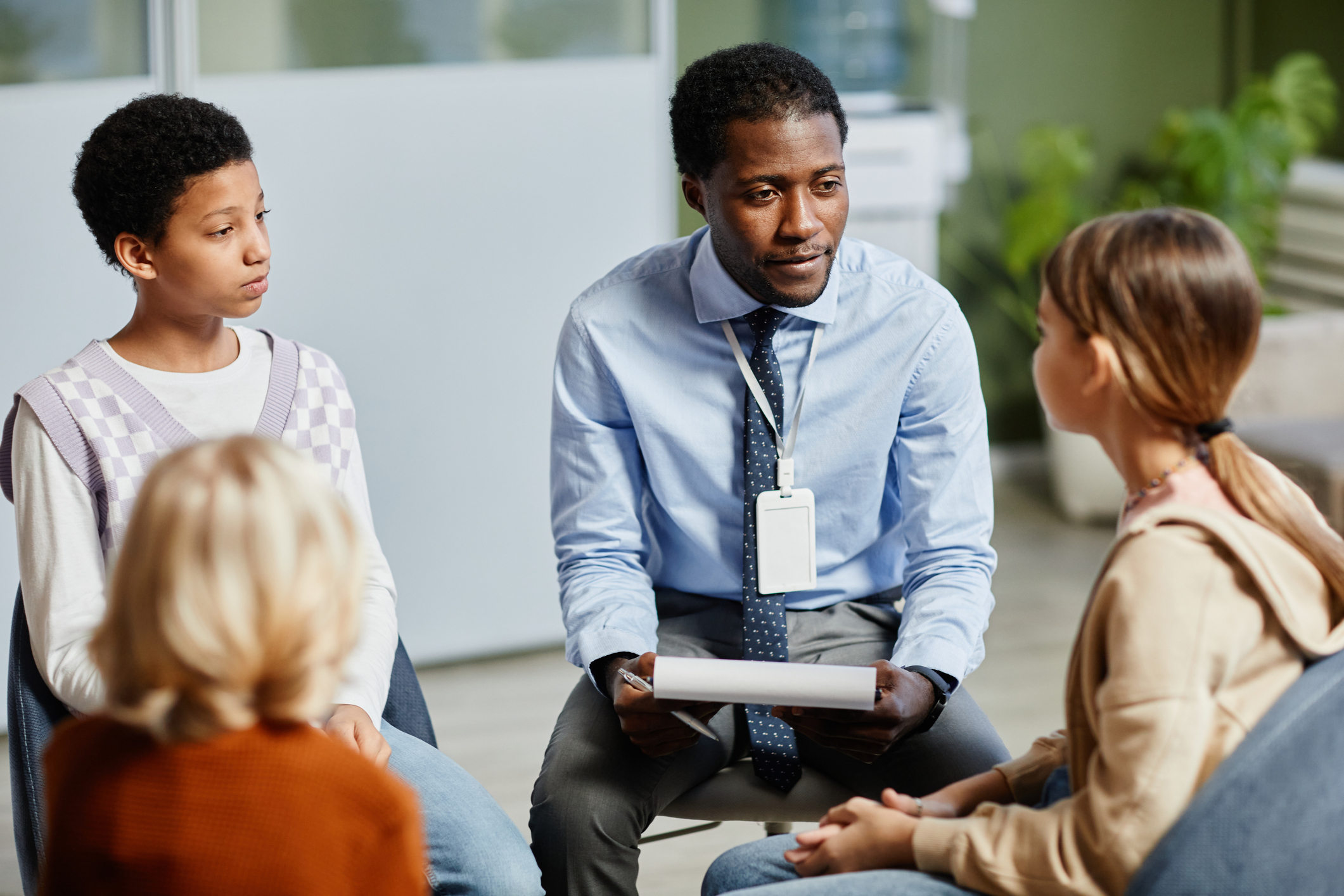 A male marriage and family therapist hosting a childrens group therapy session.