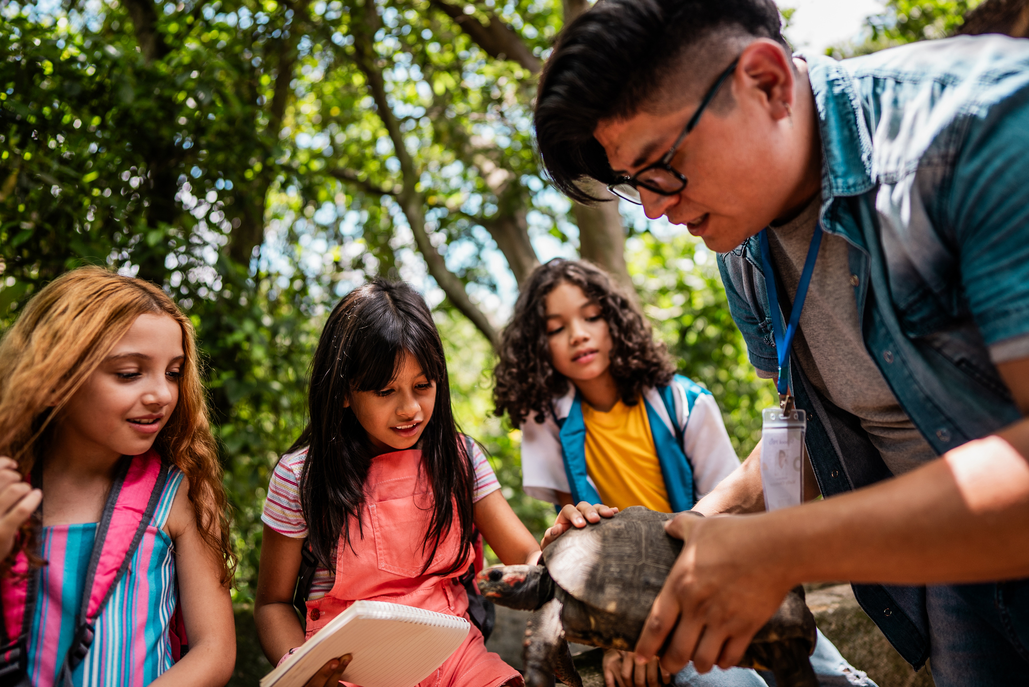 Teacher showing turtle to children during a field trip
