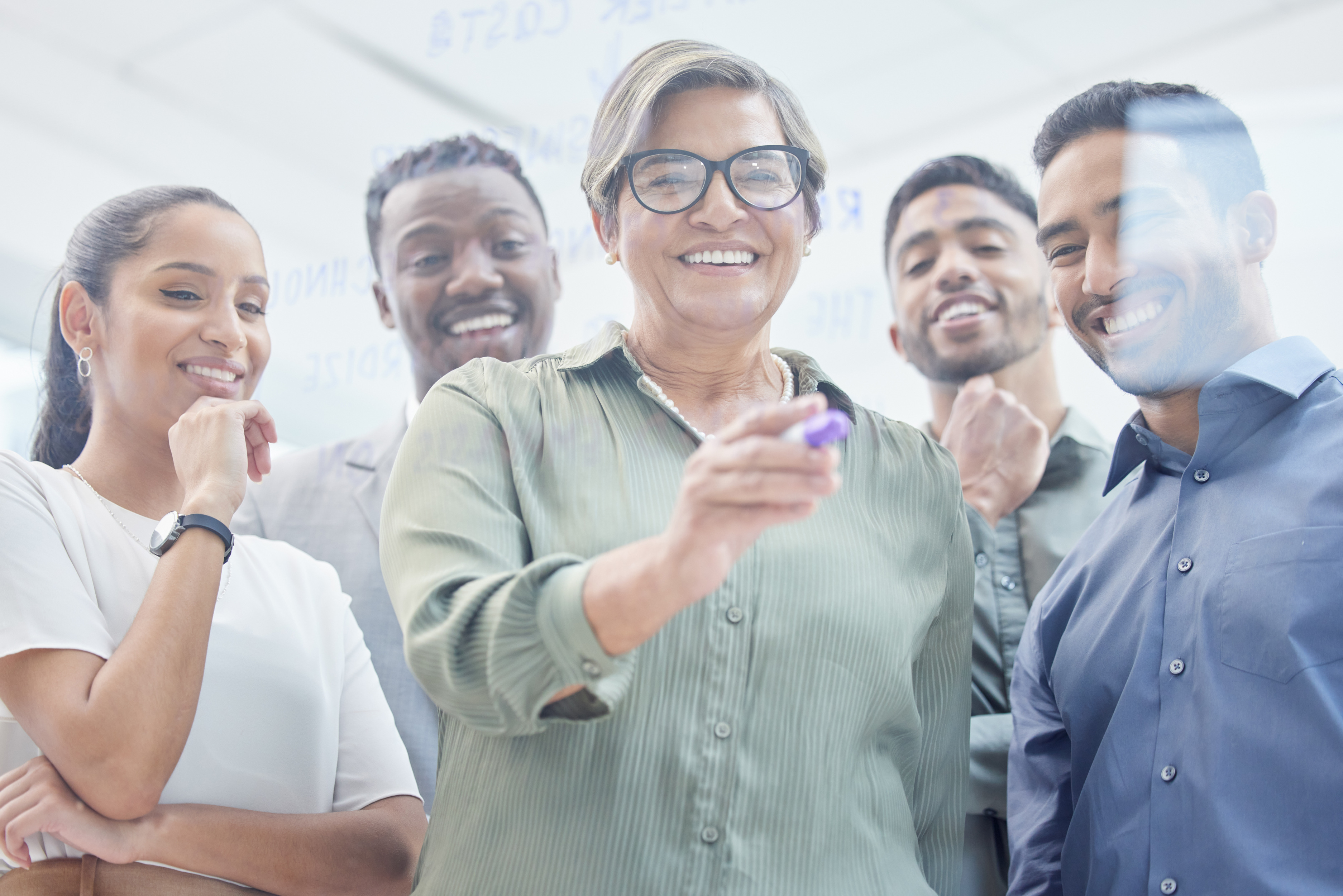 A diverse group of school district faculty gathers around a board to review the agenda.
