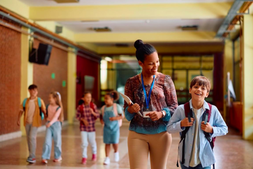 A special education administrator talks with a student in a school hallway.