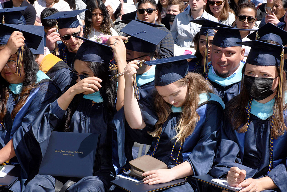 students in caps and gowns sitting at graduation